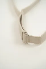 Riñonera negra de cuero sintético con correa ajustable y cierre superior con cremallera. Decorada con tachas plateadas en el borde inferior.