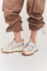 Championes color beige con detalles en marrón, con ajuste de velcro y suela track blanca y marrón.