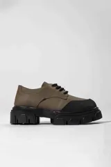 Zapato oxford negro con suela gruesa y diseño de líneas sencillas.