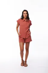 Camisa color ladrillo de algodón con cuello clásico, manga corta con dobladillo y cierre frontal con botones.