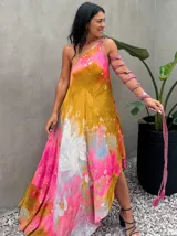 Vestido largo de tela fluida, color verde esmeralda con estampado abstracto en tonos turquesa y detalles dorados. Diseño asimétrico con un solo tirante tejido en el hombro.