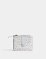 Billetera pequeña de cuerina color crema con estampado de flores azules. Cuenta con cierre superior, puller de cuerina celeste, compartimentos para tarjetas y lazo con broche a presión para cerrado.