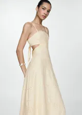 Vestido midi color crema con bordado calado, breteles finos, escote cuadrado, corte evasé, cut-out en la cintura y cierre lateral con cremallera.
