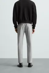 Pantalón largo de vestir gris claro con estampado de cuadros, corte slim fit y cintura elástica. Confeccionado en tejido con alta elasticidad, bolsillos frontales y cierre frontal con cremallera y botón.