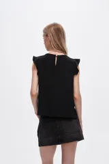 Blusa roja de poliéster con cuello a la base y volados en los hombros.