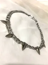 Gargantilla plateada de acero inoxidable con cadena de eslabones y púas metálicas.