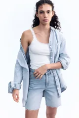 Musculosa blanca de algodón acanalado con breteles finos y escote redondo pronunciado con ribete de encaje.