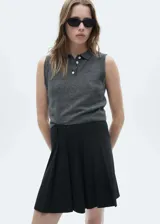 Minifalda negra con diseño de tablas y estampado de raya diplomática. Cierre de cremallera invisible en la parte posterior.