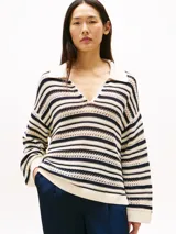Sweater de punto calado a rayas horizontales color crudo y azul marino, con cuello tipo chomba blanco y corte oversize.