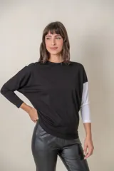 Remera de algodón color negro con una manga blanca y diseño de manga caída.