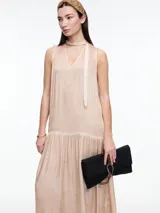 Vestido largo gris de viscosa con efecto gastado, sin mangas, escote halter y tira fina para anudar al cuello tipo choker. Falda con recorte y frunces.