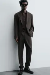 Pantalón de vestir negro de lana, corte recto, con bolsillos laterales y traseros de ojal con botón.
