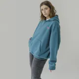 Canguro azul petróleo con capucha y bolsillo delantero, con logo 'Human Being' bordado en rosa en el pecho.