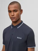 Remera polo de algodón color negro, corte regular fit, con detalles en el cuello y logo de la marca.