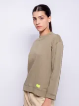 Buzo de manga larga color verde militar, con cuello redondo y diseño de costuras visibles.