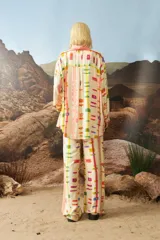 Camisa estampada color beige con diseño abstracto multicolor, de mangas largas y corte holgado.