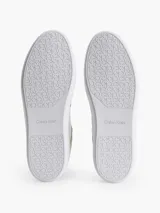 Zapatillas urbanas Calvin Klein color blanco con detalles en cuero sintético y gamuza color crema. Presentan una franja lateral negra con el logo de la marca.