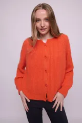 Cárdigan color ocre de tejido de punto con mohair, con cuello redondo, mangas largas y botones al tono. Silueta ligeramente oversize.