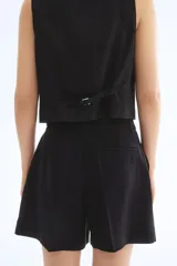 Short negro de vestir con cierre y botón, bolsillos al bies y bolsillo trasero decorativo. Piernas con pinzas y pliegues adelante y atrás.