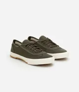 Championes casuales color verde militar, confeccionados en sarga con recortes laterales y ajuste con cordones. Suela de goma blanca con base marrón.