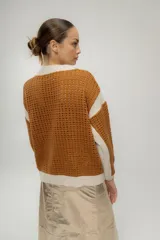 Chaqueta estilo bomber tejida color marrón con detalles en beige, cierre frontal y bolsillos delanteros.