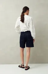 Bermuda de jean azul de corte clásico y largo a la rodilla.