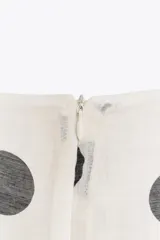 Bermuda blanca con estampado de lunares negros, de tiro medio con pinzas y bolsillos frontales.