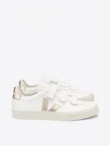 Zapatilla blanca con cierre de velcro, fabricada con cuero ChromeFree y suela de caucho amazónico, un diseño sostenible y cómodo.