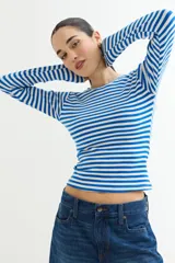 Remera de manga larga ajustada al cuerpo, con cuello redondo y estampado de rayas horizontales blancas y negras.