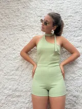 Mono corto color verde agua, con escote halter asimétrico y detalle de lazo al cuello.