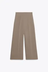 Pantalón culotte color beige, de tiro alto y pierna ancha. Cierre lateral con cremallera oculta en costura.