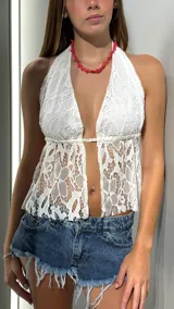 Top blanco de encaje con escote halter y espalda descubierta.