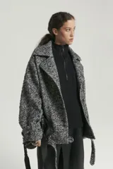 Tapado de lana multicolor con diseño de espiga, doble botonadura, cuello con solapas y cinturón con hebilla.