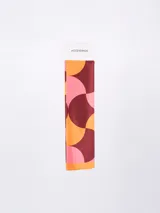 Pañuelo rectangular con estampado abstracto en tonos terracota, negro, blanco y beige.