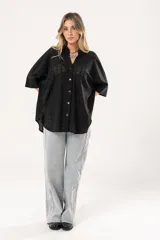 Camisa negra con calados, escote en V, abotonada y manga 3/4.