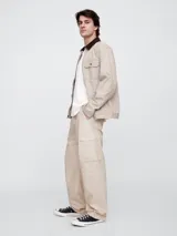 Pantalón cargo color beige, corte holgado, con bolsillos laterales con solapa y ajuste con cordón en la cintura.