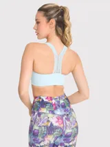 Top deportivo celeste con soporte medio, almohadillas removibles, tirantes anchos y espalda deportiva. Presenta detalles de encaje en la banda inferior y en los tirantes.
