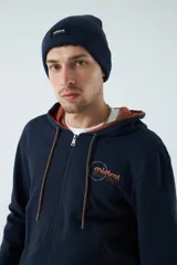 Campera de felpa color ladrillo con capucha ajustable, cierre frontal y bolsillos laterales con cierre. Tiene puños y logo bordado en la espalda.