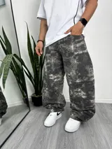 Pantalón baggy de denim con estampado abstracto en tonos grises y blancos.
