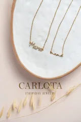 Collar dorado con dije de la palabra 'mamá' en letra cursiva, con cadena de eslabones finos.