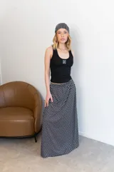 Pollera larga de viscosa con estampado de lunares blancos sobre fondo negro.