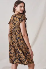 Vestido midi de viscosa con estampado floral en tonos ocre sobre fondo negro. Tiene corte evasé, mangas cortas con volados y largo hasta la rodilla.