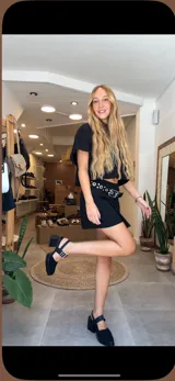 Camisa blanca de lino con bordados florales calados, cuello clásico, cierre frontal con botones y mangas largas.