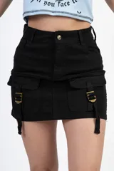 Minifalda negra de gabardina con bolsillos cargo laterales con solapa y hebillas decorativas.