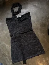 Top de lurex negro con diseño sin mangas y lazo en el cuello.