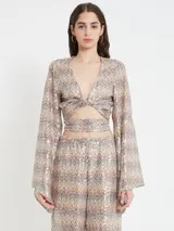 Top con estampado multicolor y lentejuelas, de mangas acampanadas y cierre con nudo en el pecho.