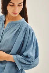 Camisa amarilla de algodón con corte amplio, cuello redondo y mangas 3/4 con puños elásticos.