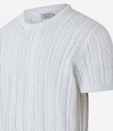 Remera blanca de algodón con textura de punto en líneas verticales, cuello redondo y mangas cortas.