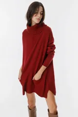 Vestido sweater de punto color bordó, con cuello alto, mangas largas y bolsillos delanteros.