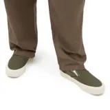 Championes slip-on color verde, con suela blanca y diseño clásico de Vans.
